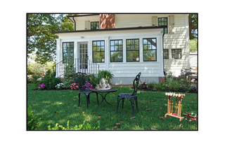 house with table and tea set on lawn table with croquet