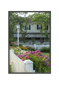 bird house and garden flowers with white picket fence