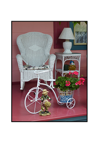 pink porch with gnome, flower pot bicycle, wicker chair and lamp stand