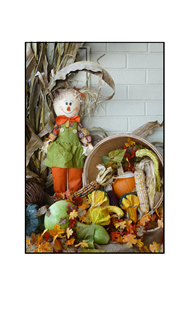 scarecrow with veggies and autumn leaves