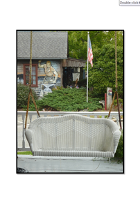 White wicker swing bench with blacksmith background