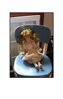 Doll sitting in chair waiting for her shoe laces to be tied