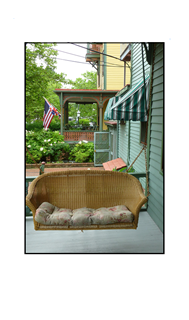 Porch with brown wicker swing bench